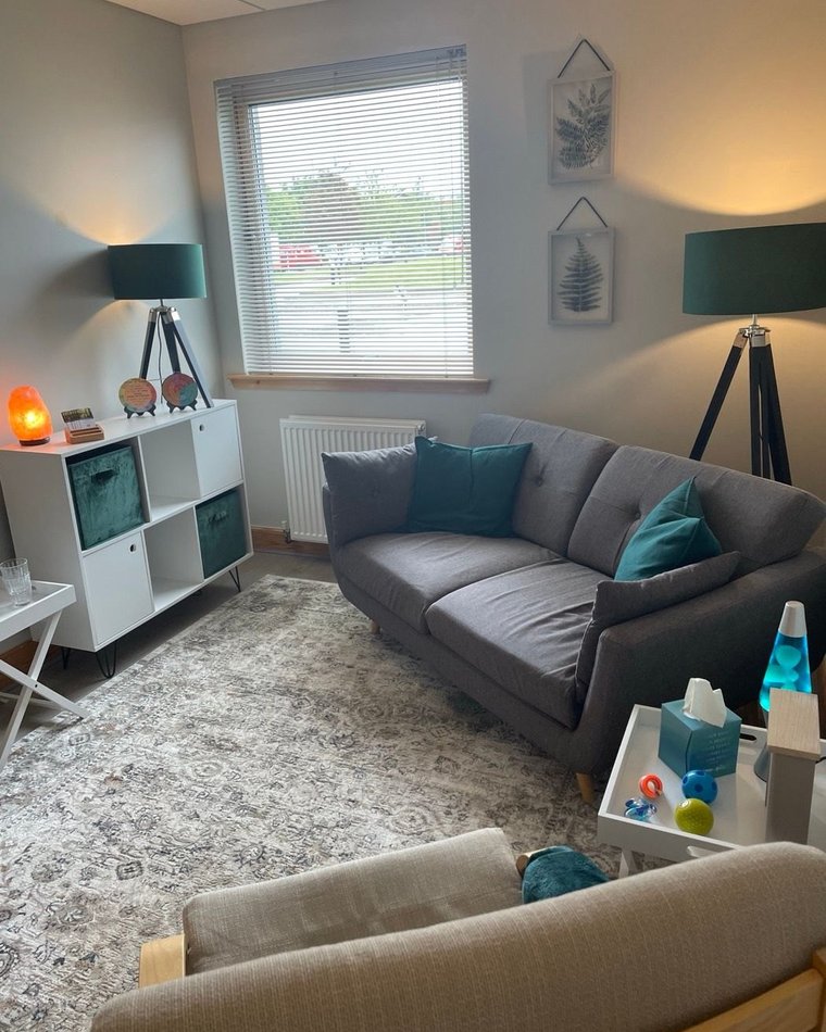 The counselling room in Westhill - a warm, softly-lit space with a sofa, lamps and plants